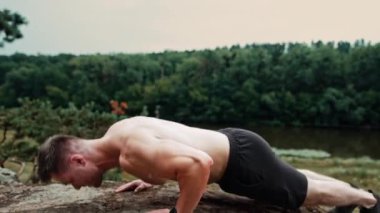Şınav çekerken kısa giyen güçlü beyaz adam. Sporcu güzel doğada egzersiz yapıyor..