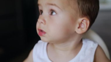 Küçük beyaz çocuk yemek yemeyi reddediyor. Çocuk arkasını döner ama sonunda yiyeceği alır. Portreyi kapat.