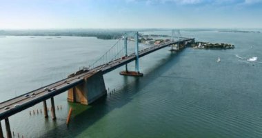 Arabalar East River üzerindeki asma köprünün yanından geçiyor. Güneşli bir günde New York 'taki Throgs Boyun Köprüsü' nün güzel manzarası.