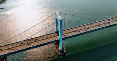 Nakliye gemisi Throgs Boyun Köprüsü 'nden hızla geçiyor. Doğu Nehri 'ndeki hava manzarası ve güneşli bir günde asma köprü..
