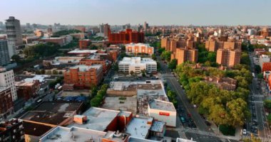 New York şehrinde çeşitli apartman blokları. Gün batımında çatıların üstünde İHA görüntüleri.