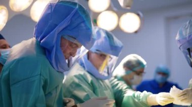 Özel korumalı kask takan bir grup doktor operasyon başlatıyorlar. Modern hastanede ortopedik cerrahi.
