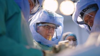 Operasyondaki cerrahların bakışları. Koruyucu miğferli doktorlar ortopedik prosedür uyguluyorlar. Düşük açı görünümü.