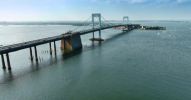 Geniş bir nehir ve üzerinde güzel bir asma köprü. Nakliye gemisi New York, ABD 'deki Throgs Neck Köprüsü' nden geçiyor..