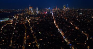 New York 'un gece manzarasında hafif otoyol çizgileri. Havadan bakıldığında parlak bir şehir..
