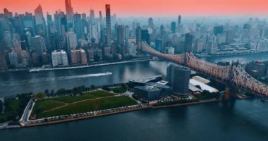 Queensboro Köprüsü veya Doğu Nehri üzerindeki 59. Cadde Köprüsü. Suda yüzen sürat teknesi. Pembe gökyüzünün altındaki New York silueti.