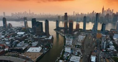 Hudson Nehri New York 'ta akıyor. Akşamları kalabalık bir metropol. Gökyüzünde turuncu bulutlar.