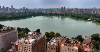 New York Central Park 'taki göl manzarası. Etrafında muhteşem binalar ve görkemli gökdelenler var. Kuş bakışı bakış açısı.