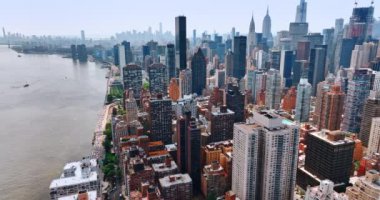 Güneşli bir günde New York 'ta, yoğun inşa edilmiş East River rıhtımının üzerinde uçmak. Güzel gökdelenler şehir panoramasından göze çarpıyor. Üst görünüm.