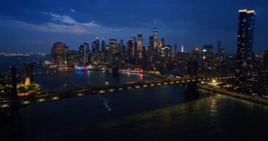 Doğu Nehri üzerindeki güzel aydınlatılmış köprüler gece vakti. Arka planda ışıkları açık gökdelenler. New York tepeden gün batımından sonra.