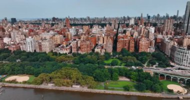 New York 'un güzel yeşil rıhtımı boyunca insansız hava aracı görüntüleri. Çok katlı binaların olduğu bir manzara gökdelenlerle değişiyor..