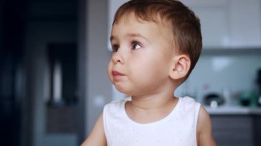 Anne çocuğunu kaşıkla beslemeye çalışır. Tatlı erkek bebek yemek yemeyi reddediyor. Kapat..