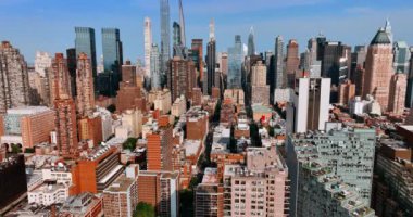 Parlak güneş New York 'un çok katlı binalarının ve gökdelenlerinin cephelerini aydınlatıyor. Gökyüzü perspektifinden Metropolis şehir manzarası.