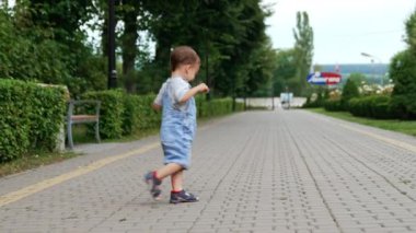 Parkta daireler çizen mutlu beyaz çocuk. Sağlıklı aktif bir çocuk yazın dışarıda eğleniyor..