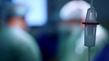 İlaç damlaları atık deposunun içine düşer. Kapatın. Doktorlar bulanık arkaplanda ameliyathanede çalışıyorlar..