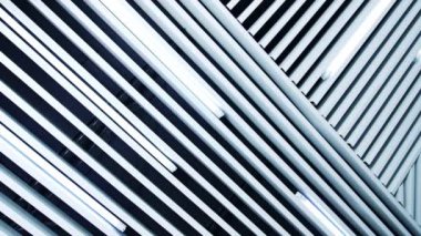 Tavanda uzun gün ışığı lambaları. Aydınlatma ekipmanına paralel beyaz kalaslar.