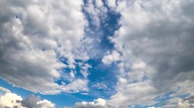 Mavi gökyüzünü kaplayan yumuşak beyaz bulutlar. Yaz günlerinde düşük açılı görünüm zamanlaması.