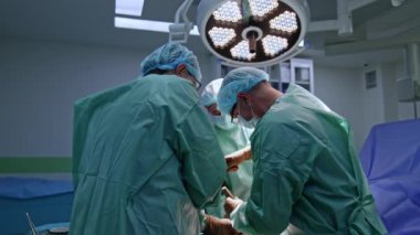 Baş cerrah ortopedi ameliyatında çekiç ve keski kullanır. Profesyonele yardım eden iki doktor..