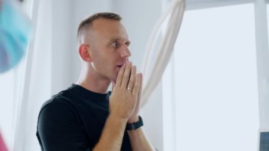 Adam dua etmek için önünde el ele tutuşuyor. Hastanedeki bebeğinin doğumu sırasındaki endişeli koca portresi.