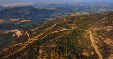 Dağları geçen dört şeritli yol. ABD 'deki Sierra Ulusal Ormanı' nın güneşli manzarası havadan bakıldığında.