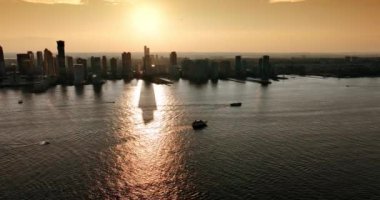 Nehrin üzerinde duran ve suya yansıyan gökdelenlerin siluetleri. Altın saatinde New York silueti. Üst görünüm.