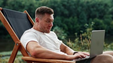 Kafkasyalı adam bilgisayarının ekranına baktığında şaşırmış görünüyor. Bağımsız çalışan doğada bilgisayarla çalışır..