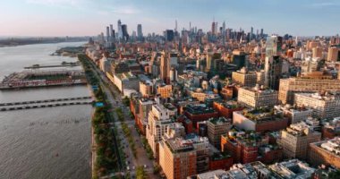 Günbatımında New York 'un yoğun bir manzarası var. Nehrin yanındaki rıhtımda hayat dolu bir otoban. Üst görünüm.