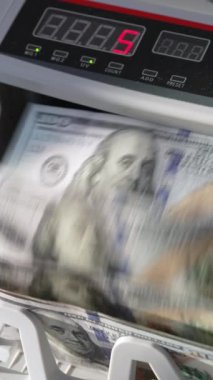 Banka işlemleri için otomatik para makinesi. Modern cihaz 100 dolarlık banknotları sayıyor. Kapatın. Dikey video