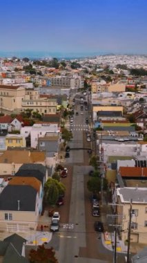 Parlak San Francisco, California, ABD 'nin güzel, rahat caddeleri ve evleri. Mavi gökyüzünün arka planında sisli ufku olan güneşli şehir manzarası. Dikey video