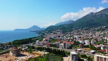 Karadağ 'daki yeşil dağların yamaçlarında yer alan güzel bir şehir barı. Göz kamaştırıcı doğanın arka planında güneşli şehir manzarası. Hava perspektifi.