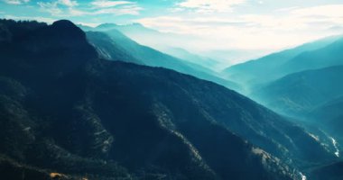 Yeşilliklerle kaplı muhteşem sıradağlar. Mavi sisli güzel kayalar. Üst görünüm.