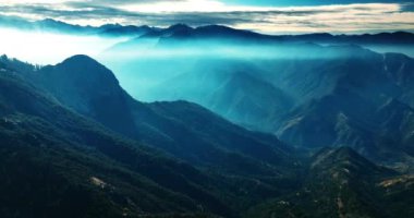 Mavi sisli muhteşem dağlar. Kaliforniya 'nın yeşilliklerle kaplı sıradağlarının muhteşem manzarası. Üst görünüm.