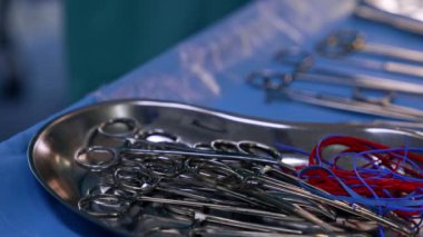 Metal tepside bir sürü pens var. Ameliyat için cerrahi aletler hazır. Kapatın. Bulanık arkaplan.