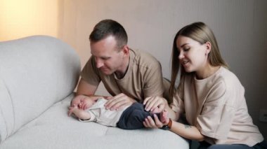 Kanepede uyuyan küçük bir çocuk. Sevgi dolu ebeveynler, sevgi dolu bebekleri öpüp okşar..