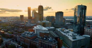 Yüksek binaların arkasında saklanan batan güneşin son ışınları. Boston, Massachusetts, ABD 'nin hava manzarası.