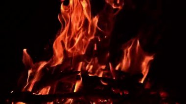 Kamp ateşinin yandığını ve hipnotize edici bir şekilde hareket ettiğini görmek huzur verici. Sıcak bir ateşte yanan odun parçaları. Kapat..