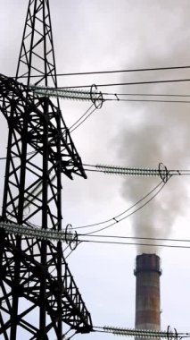 Sigara piposunun arka planında elektrik direği var. Endüstriyel borulardan yayılan zararlı duman. Hava kirliliği. Dikey video
