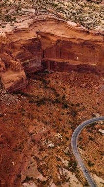 Bryce Canyon 'un Utah, ABD' deki muhteşem çekimi. Kayalıklar 'ın eteklerinden bir kaç araba geçerken yol geliyor. Havadan bakış açısı. Dikey video