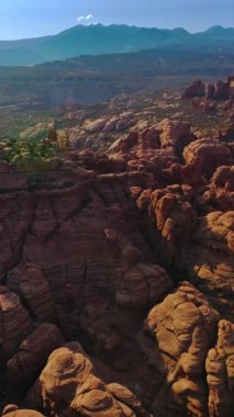 Utah, ABD 'deki Arches Ulusal Parkı' ndaki Sunlit Kanyon Dağları. Dengesiz arazideki inanılmaz kayaların üzerinden yükseliyor. Dikey video
