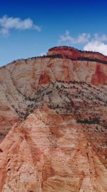 Harika bir kayanın tepesine, kanyonlardan birine bakıyorum. Utah Ulusal Parkı 'nın güzel güneşli görüntüleri, alçak görüş açısı. Dikey video