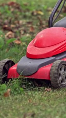 Çim biçme makinesi. Çimleri biçen adamın yakın görüntüsü