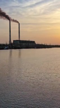 Yansıma nehri olan günbatımı bulutları. Gün batımında nehir kıyısında manzara