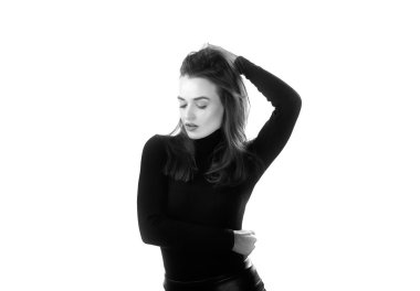 Siyah balıkçı yaka giyen kadın pozu. Siyah beyaz bir fotoğraf. Siyah balıkçı yaka kazak giyen uzun siyah saçlı bir kadın..