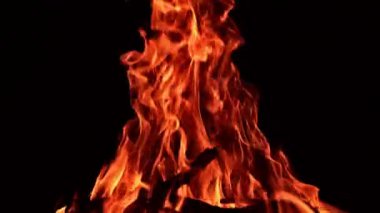 Gece büyük bir kamp ateşi yanıyor. Siyah çubuklar şenlik ateşinde kırmızı ateşle yanar. Kapat..