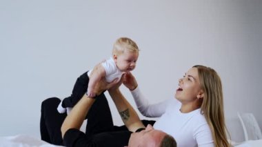 Yatakta yatan bir adam onun üzerinde bir bebek büyütür. Kadın, küçük oğluna sevgi ve mutlu bir gülümsemeyle bakar..