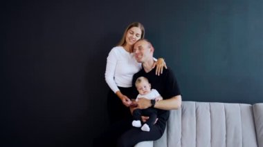 Küçük bir çocukla beyaz bir çifti kucaklamak. Siyah arka planda mutlu aile portresi.