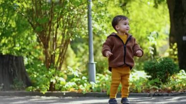 Güzel beyaz çocuk sabun köpüklerini yakalıyor. Sevimli bebek sonbaharda dışarıda eğleniyor..