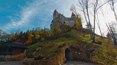 Yüksek tepede duran kalenin gizli girişi. Renkli sonbahar sezonunda Bran Kalesi 'nin alçak açılı görüntüsü.