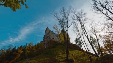 Üstünde Bran Castle olan yeşil tepe. Güzel bir ortaçağ şatosu ve güzel bir sonbahar şatosu. Düşük açı görünümü.