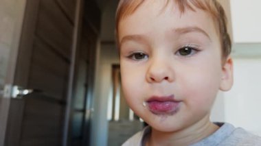 Ağzı benekli sevimli bir çocuğun yüzü. Çocuk ağzını açar ve konuşur. Kapat..